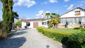 A two-story house with a gravel driveway, a small patio, and a well-maintained garden.