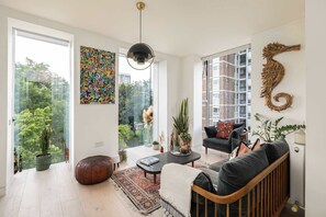 A modern living room with a sofa, coffee table, and decorative plants.