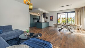 Un salon moderne avec un canapé, une table basse et un coin repas.