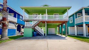 Une maison à deux étages avec un balcon, un garage et un petit porche.