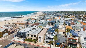 A coastal residential area with houses, a beach, and a clear sky. - 3BR Loft Ocean View Rooftop Hot Tub Parking (Newport Beach)