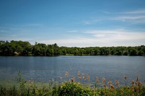 A lake with a forested shoreline and clear skies. - Lakeview Getaway With Hot Tub (Billerica)