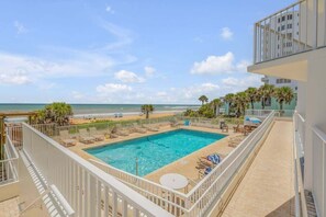 A rooftop pool with a view of the beach and ocean. - Renovated direct oceanfront corner 2/2 with a large balcony, heated pool, and garage (Ormond Beach)