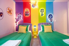 A room with two beds, colorful walls, and cartoon character decorations.