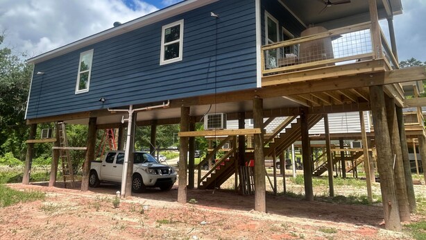 Une maison à deux étages avec un balcon et une véranda couverte.
