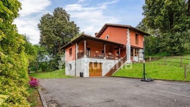 A two-story house with a balcony, a driveway, and a garden with pink flowers. - Entrencinas - country house in Collera (Ribadesella), Northern Spain (Collera)