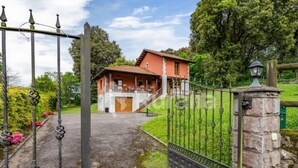 A house with a red roof, a stone entrance, and a metal gate. - Entrencinas - country house in Collera (Ribadesella), Northern Spain (Collera)
