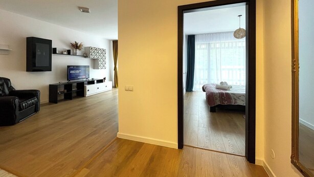 Uma sala de estar moderna com televisão de tela plana, sofá e mesa de centro.