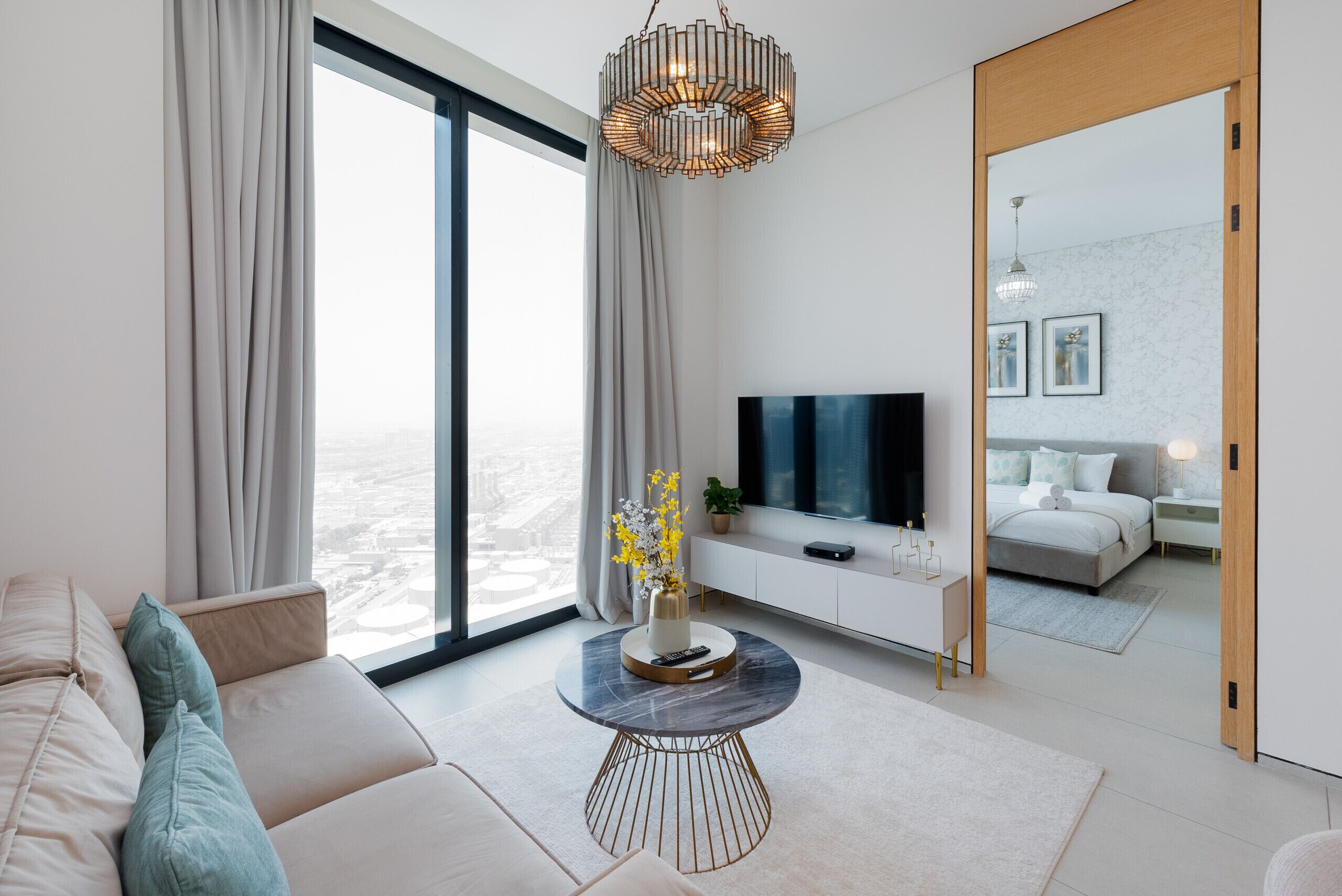 Un salon moderne avec un canapé, une table basse et un téléviseur.