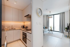 A modern kitchen with stainless steel appliances, a built-in oven, and a large window.