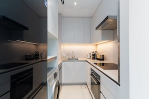 A compact kitchen with modern appliances, a built-in washing machine, and a central island.
