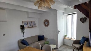 Un salon moderne avec une table en bois, un canapé gris et une petite table ronde.