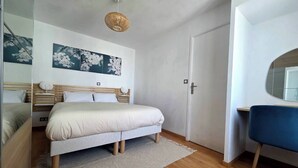 Une chambre à coucher moderne avec un lit, un bureau et un miroir.