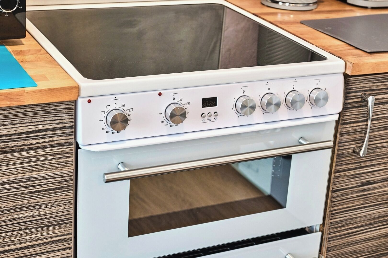 Eine moderne Küche mit eingebautem Herd und Backofen, inklusive digitaler Anzeige und mehreren Bedienelementen.