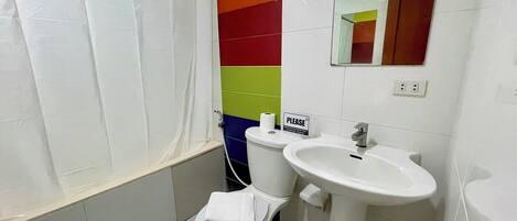 Un baño con inodoro blanco, lavamanos y cortina de ducha.