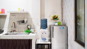 A kitchen with a sink, a water dispenser, and a refrigerator. - Colombus Homy Syariah (Karawang)