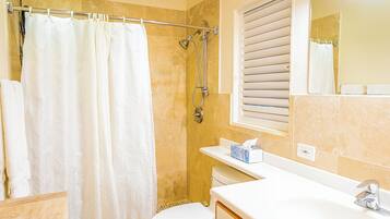 A bathroom with a shower, toilet, and sink.