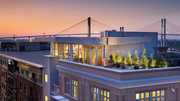 A modern building with a rooftop terrace featuring potted plants and a glass enclosure. - Charming 2-bedroom resort Located at Studio Ellis Square Savannah Georgia (Savannah)