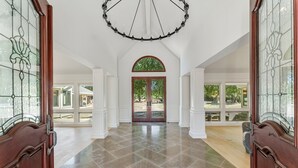Un hall d’entrée spacieux, doté d’un haut plafond, de grandes fenêtres en arc de cercle et d’une porte centrale donnant sur l’extérieur.