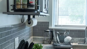 A kitchen with a black spice rack, a coffee maker, and a sink. - 18 min. to Detroit center - free parking on fenced premises (Ecorse)