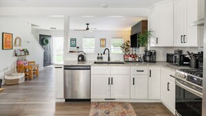 A modern kitchen with white cabinetry, stainless steel appliances, and a central island. - Family FUN! Luxury Touches, Mini Golf, Firepit, Fully Loaded (Thompson's Station)