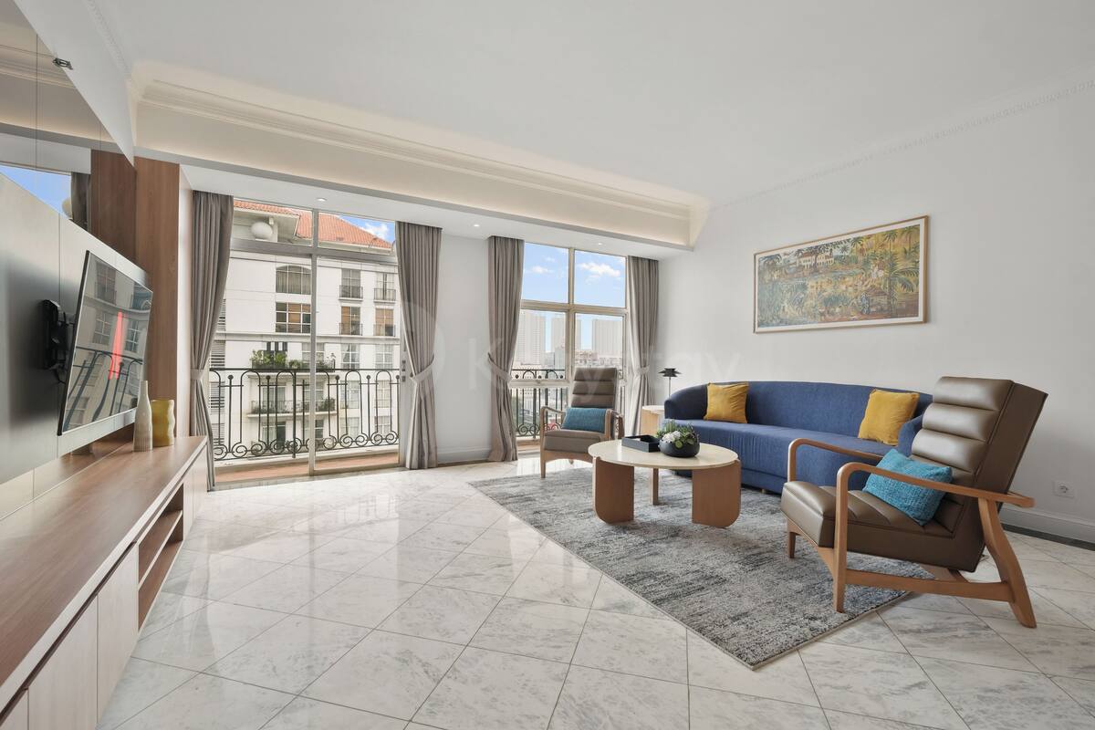 Un salon moderne avec un canapé, des fauteuils, une table basse et un téléviseur.