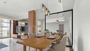 Een moderne eetruimte met een houten tafel, stoelen en hangende吊り下げライト.
