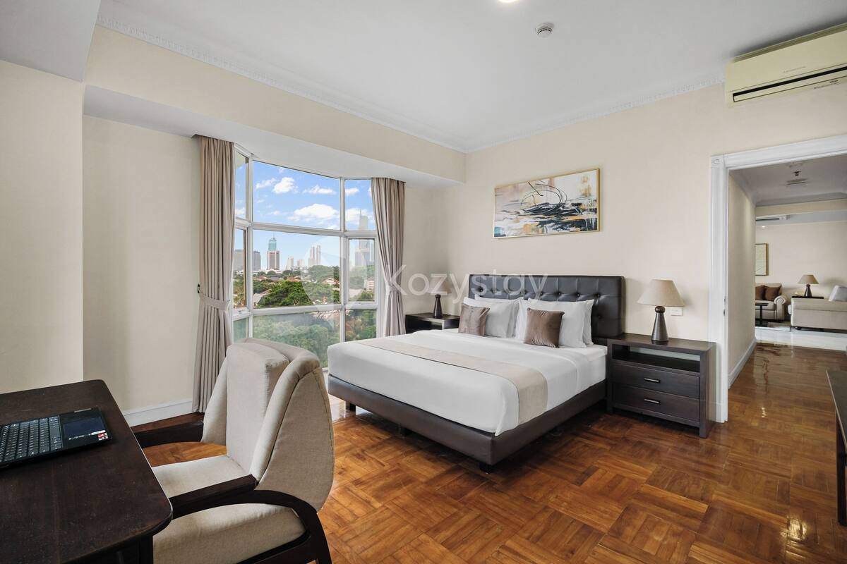 Une chambre d’hôtel avec un grand lit, un bureau et une vue sur la ville.
