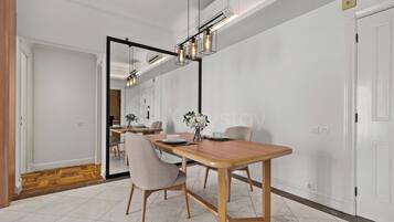 Un comedor con mesa de madera, sillas y una lámpara colgante moderna.