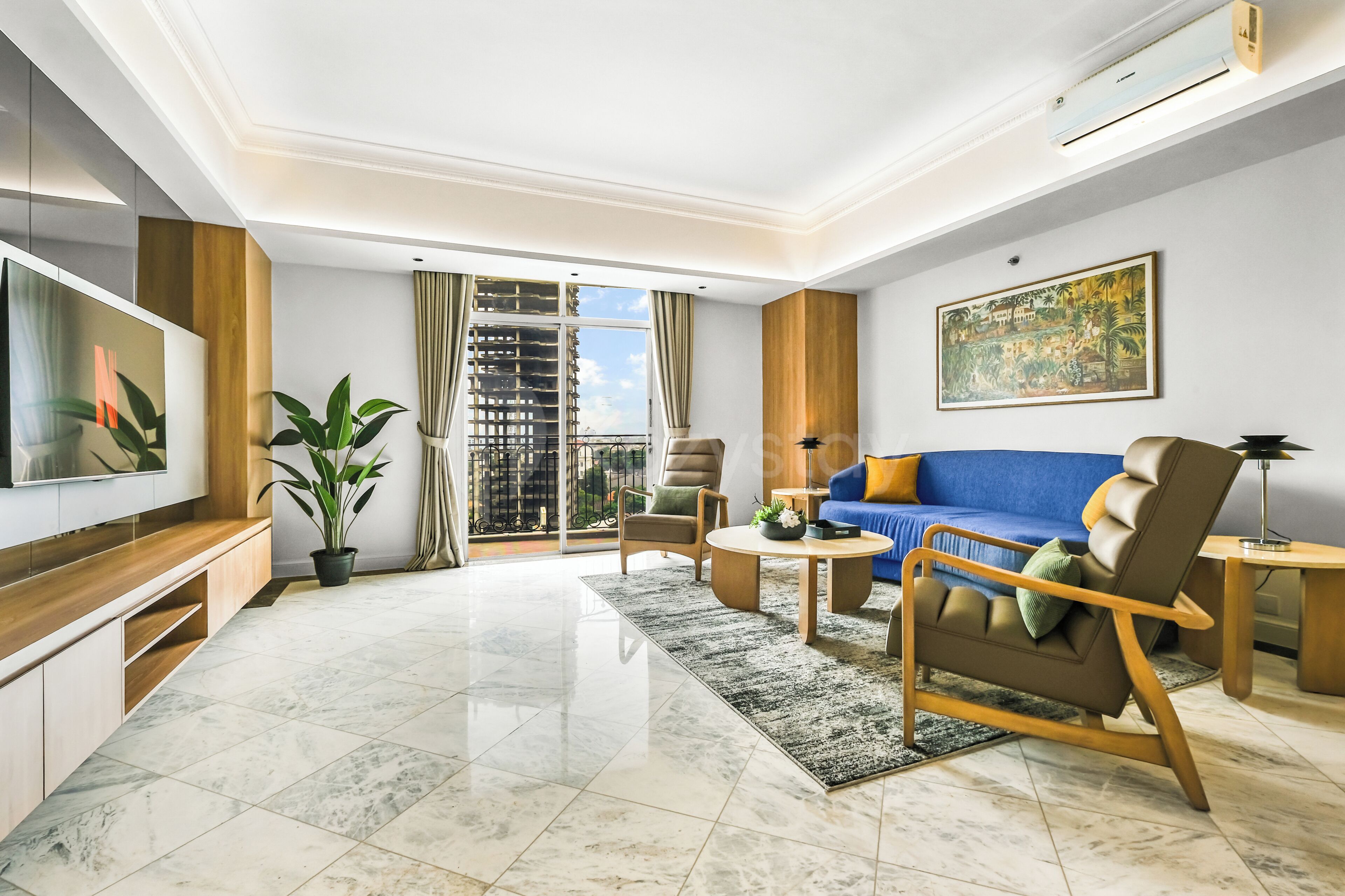A modern living room with a TV, sofa, chairs, a coffee table, and a large window with a view.