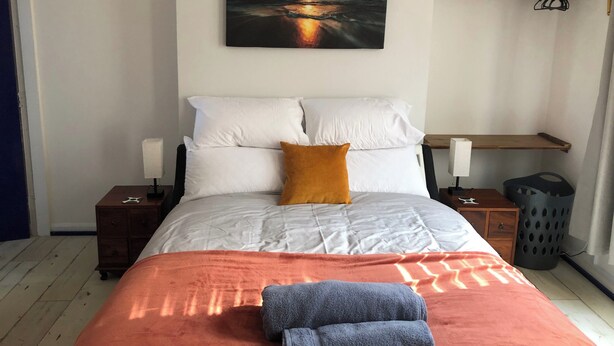 A neatly arranged bedroom with a bed, pillows, a blanket, and a towel. - Stylish flat in Chesterfield near Peak District (Chesterfield)