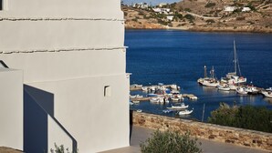 A coastal building with a view of a marina and distant hills.