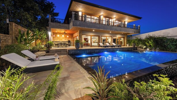 A modern two-story house with a swimming pool, outdoor seating, and a well-lit patio area. - Baan Phuttarak Villa - 4BR Private Sea View (Ko Samui)