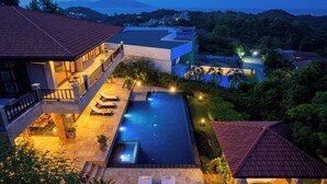 A luxurious villa with a swimming pool, multiple lounge areas, and a view of the surrounding landscape. - Baan Phuttarak Villa - 4BR Private Sea View (Ko Samui)