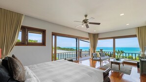 A bedroom with a large bed, a ceiling fan, and a view of the ocean. - Baan Phuttarak Villa - 4BR Private Sea View (Ko Samui)