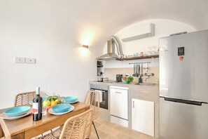 A modern kitchen with a dining table, chairs, a refrigerator, and a built-in oven. - Dimora Tra Gli Ulivi With Private Jacuzzi, Ostuni, Italy (Ostuni)