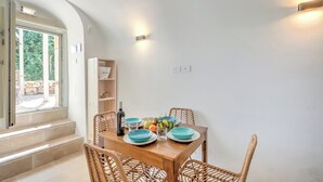 A dining area with a wooden table, blue plates, and wicker chairs.
