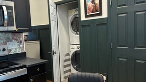 Une cuisine compacte équipée d’un four à micro-ondes, d’une cuisinière et d’une table à manger dont le plateau est en marbre.