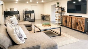 Ein modernes Wohnzimmer mit einer Couch, einem Couchtisch, einem Fernseher und einem Holzschrank.