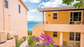 A two-story building with a balcony overlooking a body of water. - Condo by the sea (St. John's)
