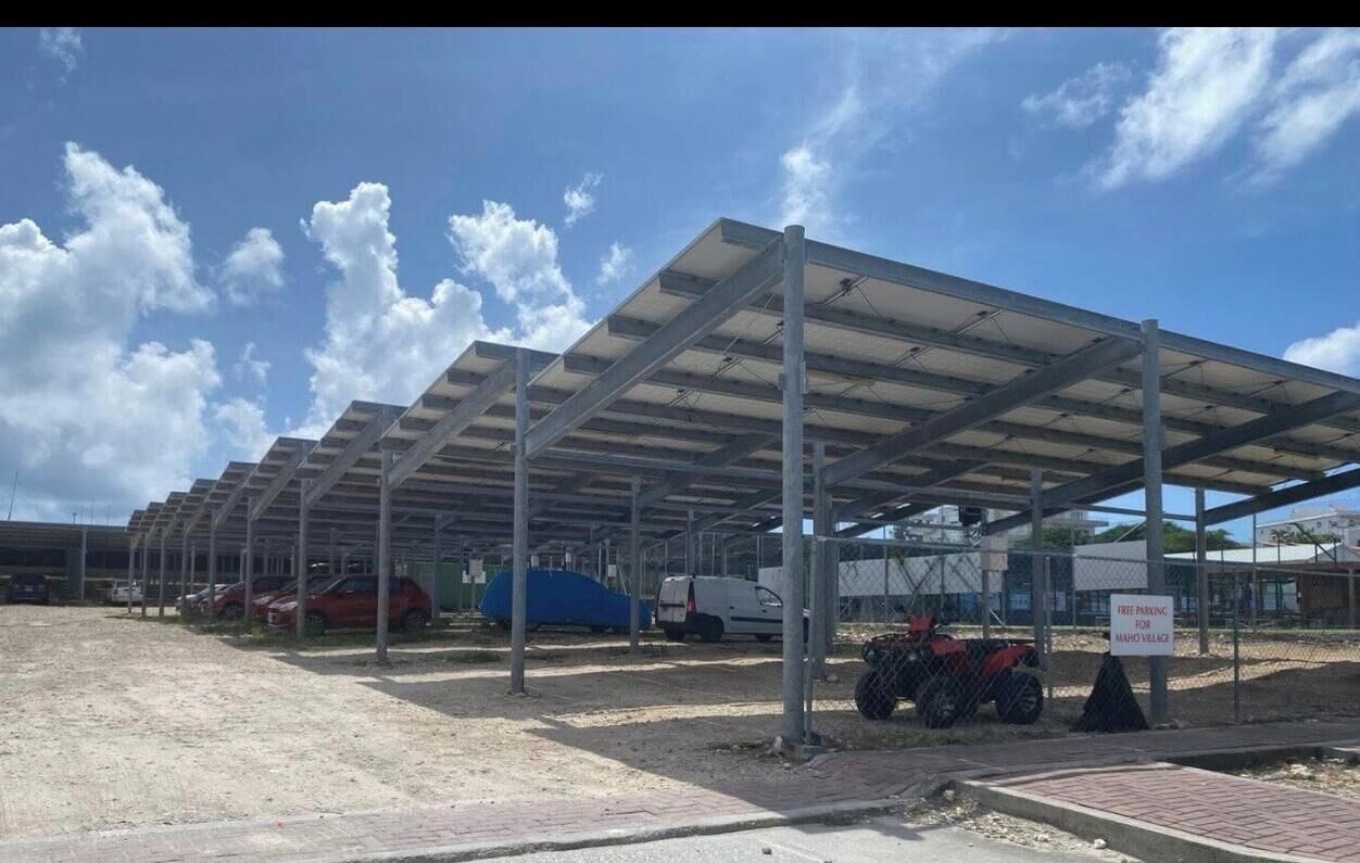 A covered parking area with a metal roof and a sign indicating free parking for residents.