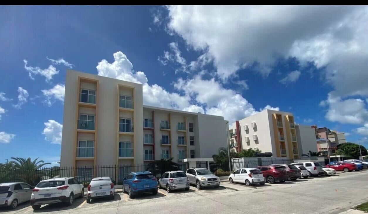 Um hotel de vários andares com um estacionamento cheio de carros.