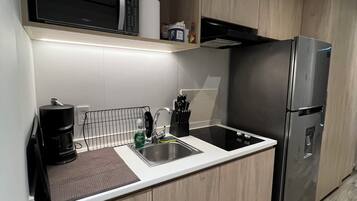 A modern kitchen with a stainless steel refrigerator, a microwave, and a coffee maker.