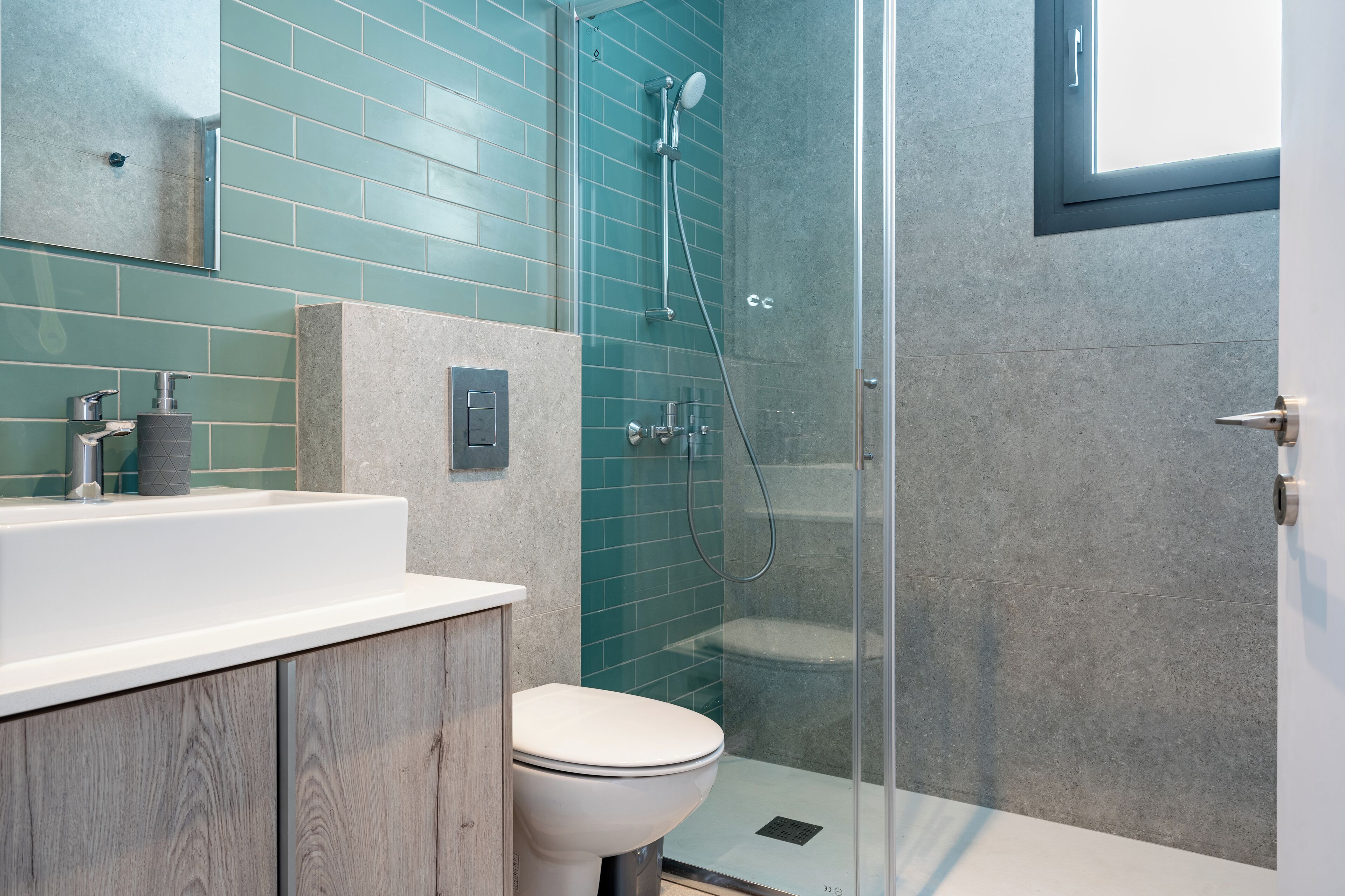 A modern bathroom with a shower, toilet, and sink.
