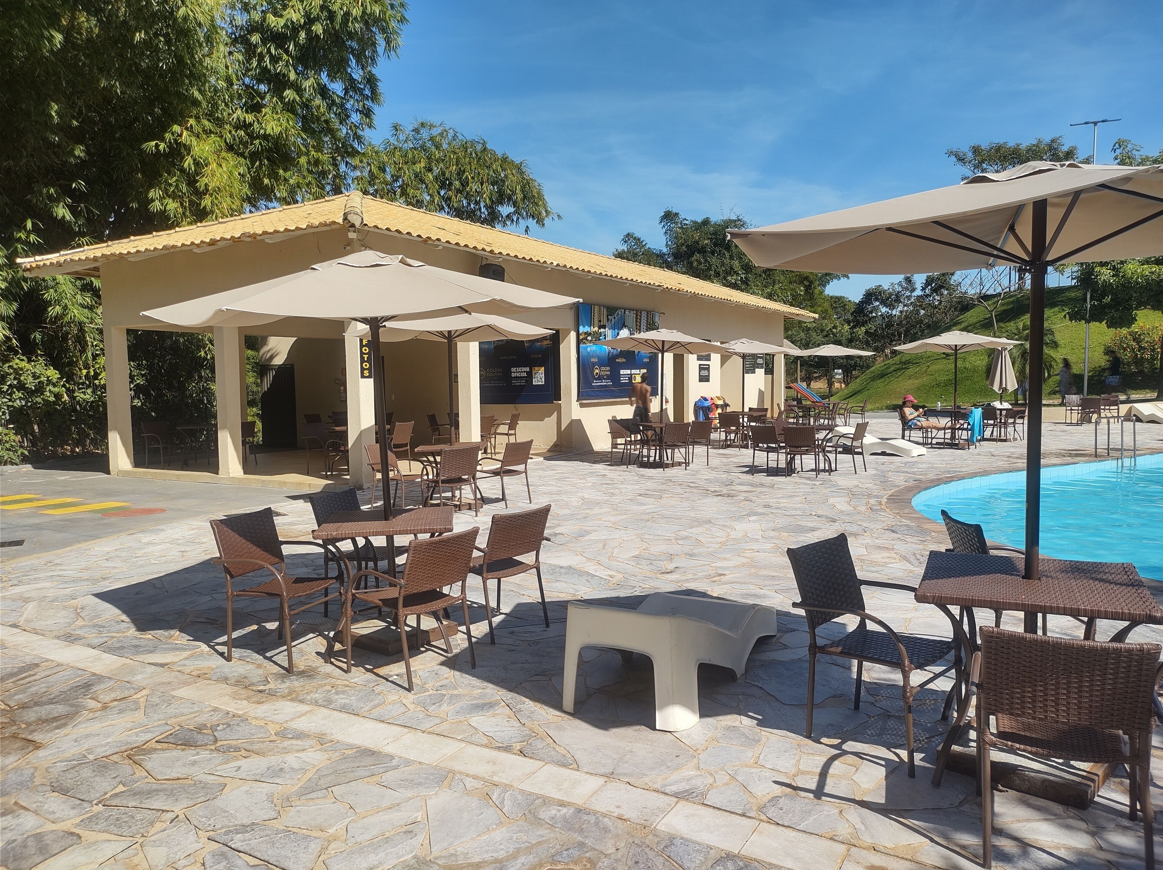 Ein Poolbereich mit Sitzgelegenheiten im Freien und einem überdachten Pavillon.