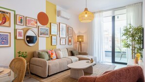 Una sala de estar moderna con un sofá, una mesa de centro y una zona de comedor con sillas.