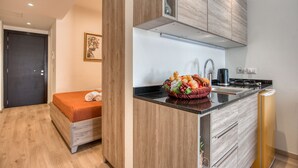 A modern kitchen with a wooden cabinet, a sink, and a countertop with a fruit basket. - RedRock Faqra - Mountain Getaway Residences W Pool & Balconies (Bqaatouta)