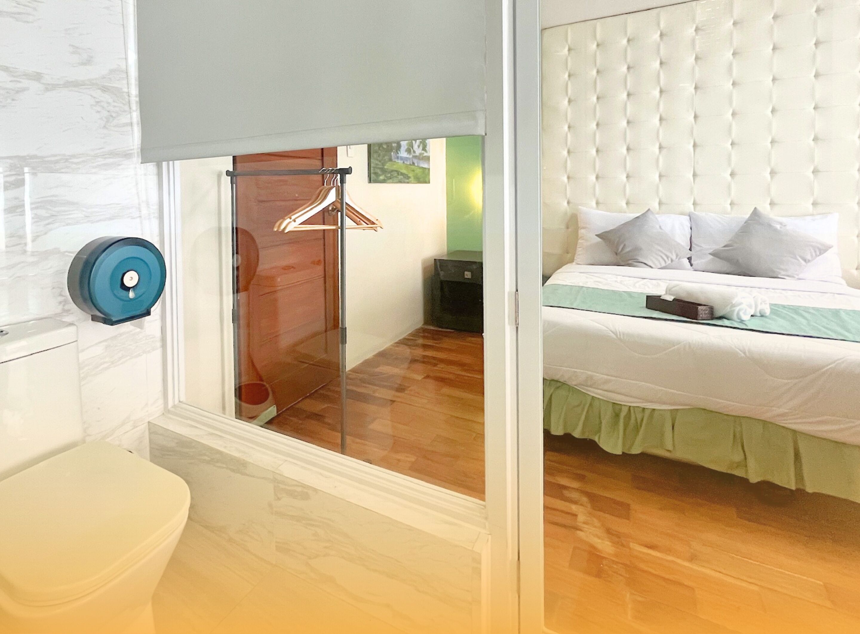 A hotel room with a bed, a bathroom, and a view of the outside.