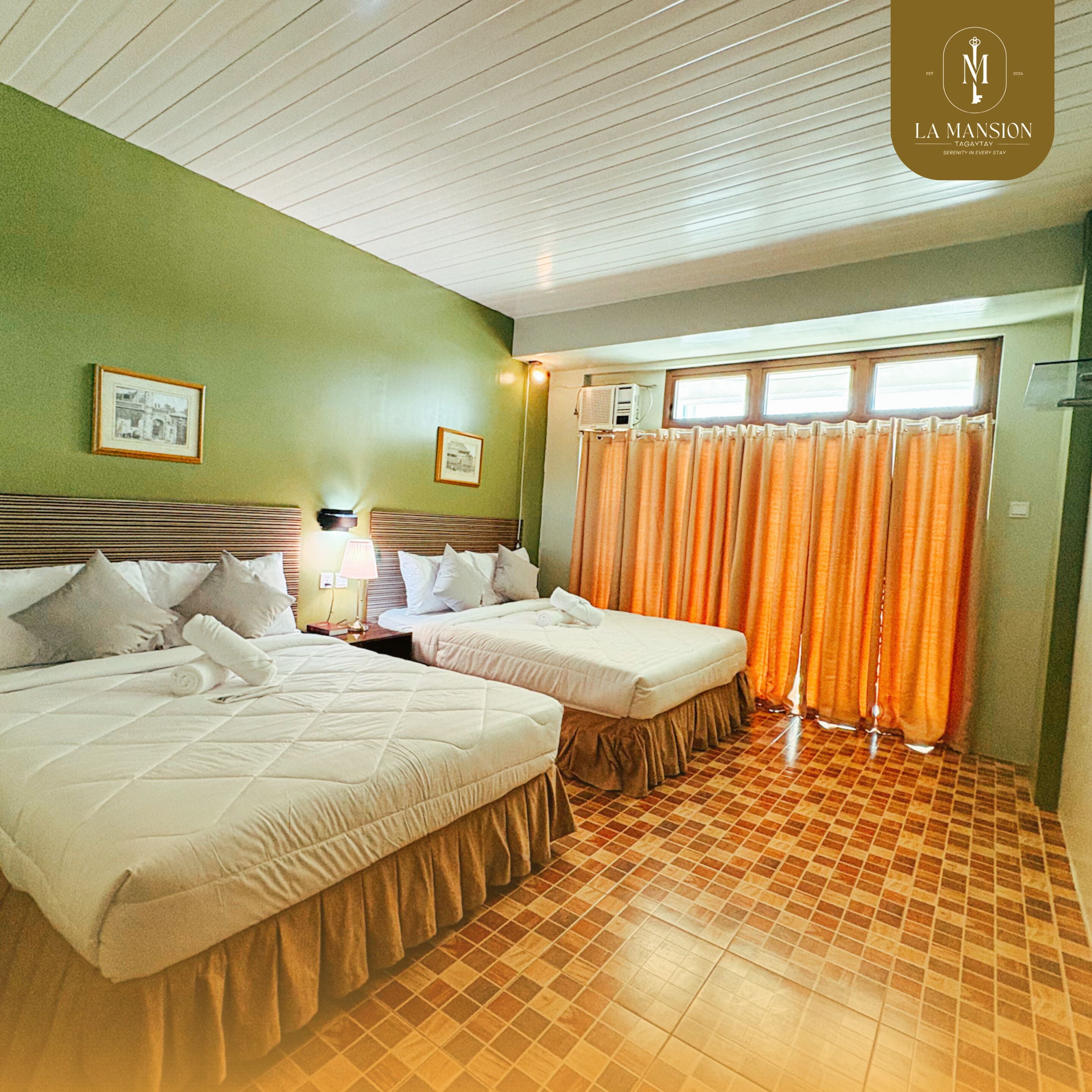 A hotel room with two beds, a window with curtains, and a tiled floor.