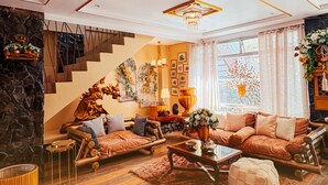 A modern living room with a wooden floor, a sofa set, a coffee table, and a staircase. - La Mansion Tagaytay (Tagaytay)